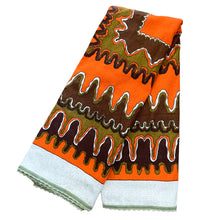Load image into Gallery viewer, Bring retro flair to your dining room with this eye-catching linen tablecloth that screams 1970s psychedelia. Rendered in cream linen with a bold abstract pattern mixing vibrant orange, warm brown, and muted olive green, it's a statement piece that refuses to blend in. A sturdy woven trim frames the design, adding both visual interest and lasting quality. Perfect for anyone who loves vintage aesthetics and isn't afraid of a little color, this tablecloth transforms an ordinary meal into a groovy experience. 
