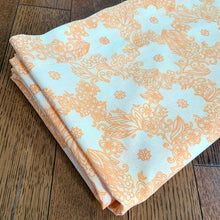 Load image into Gallery viewer, Dress your bed in this retro orange and white floral patterned poly/cotton blend twin size sheet. Manufactured by Brentford Nylons, England, circa 1970s. Create a restful slumber with these beautifully designed and well-made linens!  In excellent condition, free from stains/tears. Measures 70 x 104 inches
