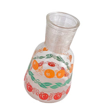 Load image into Gallery viewer, Adorable vintage clear open carafe featuring a design of oranges, red tomatoes and green leaves, plus a ribbed neck. Crafted by Hazel-Atlas Glass, USA, circa 1960s.  In excellent condition, free from chips/wear.  Measures 7 3/4 inches tall  Capacity 32 ounces   
