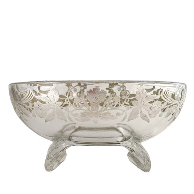 This exquisite vintage flowerlite features a clear oblong shape adorned with a delicate silver overlay of orchid flowers. Crafted by Viking Art Glass in the 1950s, it includes a glass flower frog designed to hold two taper candles and rests on elegant Chinoiserie-style scrolled feet. Ideal for creating sophisticated floral arrangements, this Hollywood Regency piece enhances any space with timeless charm, whether illuminated by candlelight or displayed on its own in both modern and vintage interiors.