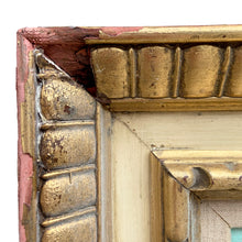 Load image into Gallery viewer, Close-up of top frame rail showing gilt egg-and-dart molding with significant plaster loss and exposed red bole ground on Herbert Otto Fiedler framed oil painting, circa 1940s 
