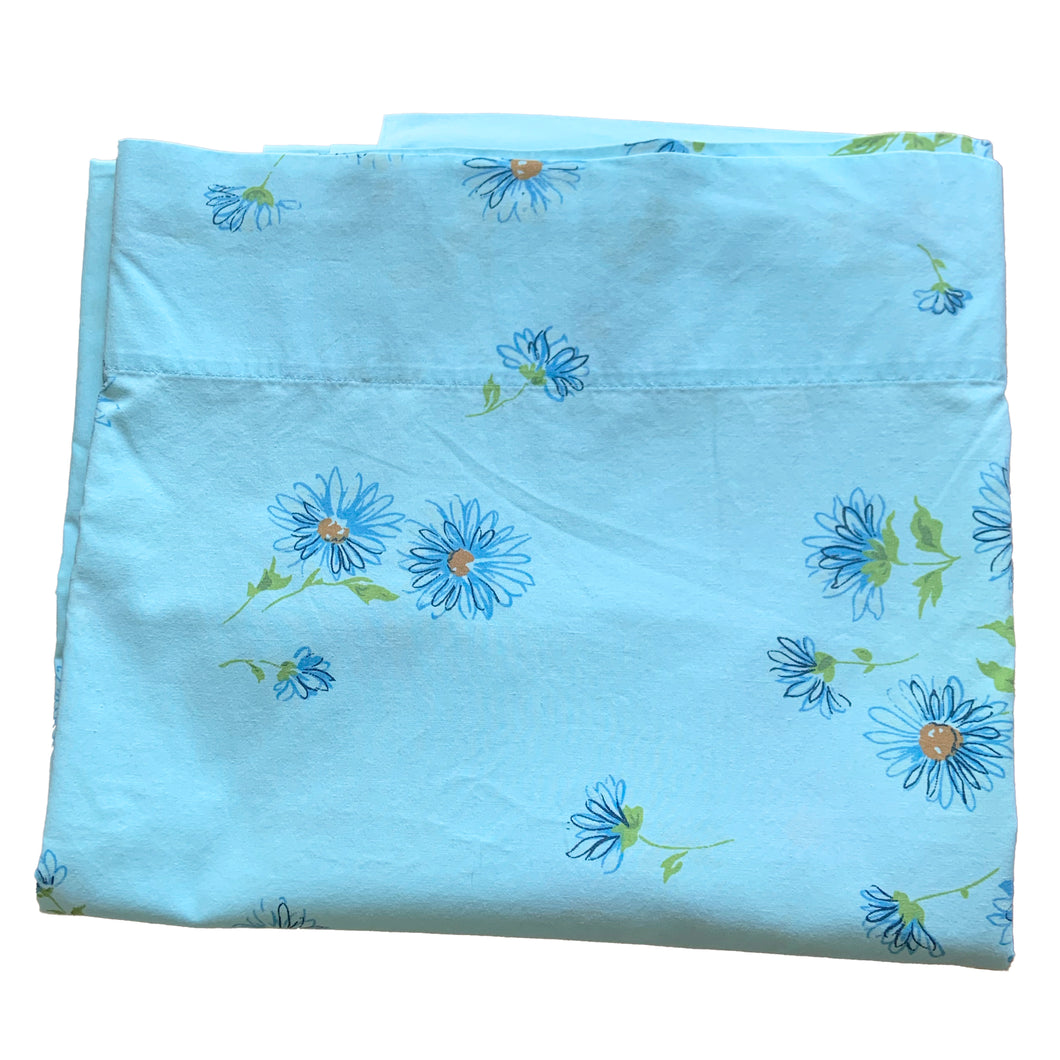 Check out the fabulous flower power of the blue poly/cotton blend fitted sheet with bouquets of daisies in shades of blue, teal, purple and white with green! Crafted by Heritage, USA, circa 1970s. We believe this sheet is new old stock as it does not appear to have been used or laundered. You'll love this super retro bed linen or repurpose for sewing or craft projects!

In excellent condition, free from stains/tears. Original label intact.

Fits a 54 x 75 inch mattress