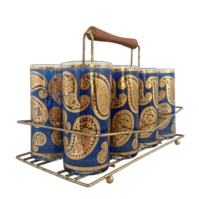 Vintage mid-century era Paisley glass cocktail tumblers in brass caddy with teak handle. These stunning tumblers feature 22 karat gold paisleys on a royal blue background on clear glass. Crafted by Culver, USA, 1950s. Highly sought after by collectors, these gorgeous tumblers will make an excellent addition to your barware collection!

In great vintage condition, no chips, minor wear.

Tumblers measure inches 2 3/4 x 5 1/2 inches

Caddy measures 12 ounces