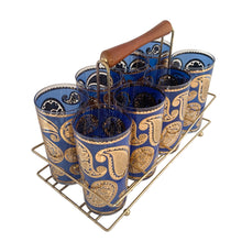 Load image into Gallery viewer, Vintage mid-century era set of eight royal blue and 22kt gold Paisley glass cocktail tumblers in brass caddy with teak handle. Crafted by Culver, USA, 1970s. Highly sought after by collectors, these gorgeous tumblers will make an excellent addition to your barware collection!

In great vintage condition, no chips, minor wear.

Tumblers measure inches 2 3/4 x 5 1/2 inches

Caddy measures 12 ounces
