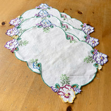 Load image into Gallery viewer, Vintage ecru linen tablecloth featuring hand embroidered pansies in purple, raspberry, blue, yellow and finished with a scalloped edge in green. It&#39;s a beauty! In great vintage condition, free from tears, minor stains on 2 pieces. Measures 18 1/2 x 13 inches
