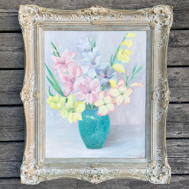 Vintage original oil on board entitled Flowers featuring a floral still life of gladiola flowers in vase in pastel shades of pink, yellow blue, and teal. Signed by Canadian artist RW Taylor, this painting was sold at The Fine Art Galleries of the T. Eaton Co, mid-20th century. Beautifully framed in an ornate white washed gold wood frame. Skillfully crafted, this one-of-a-kind piece will add an exquisite touch of warmth to your home decor.