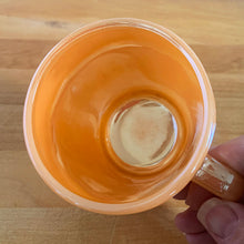 Load image into Gallery viewer, Classic and collectible Fire-King &quot;Peach Lustre&quot; D-handled mug. Made by Anchor Hocking Glass Co., USA. Your morning coffee has never looking better!  In like new condition, free from chips/cracks, minimal wear. Marked with the Anchor Hocking logo, Made in the USA, Ovenproof along with the numbers 47 and 1212.  Measures 3 x 3 1/4 inches  Capacity 10 ounces
