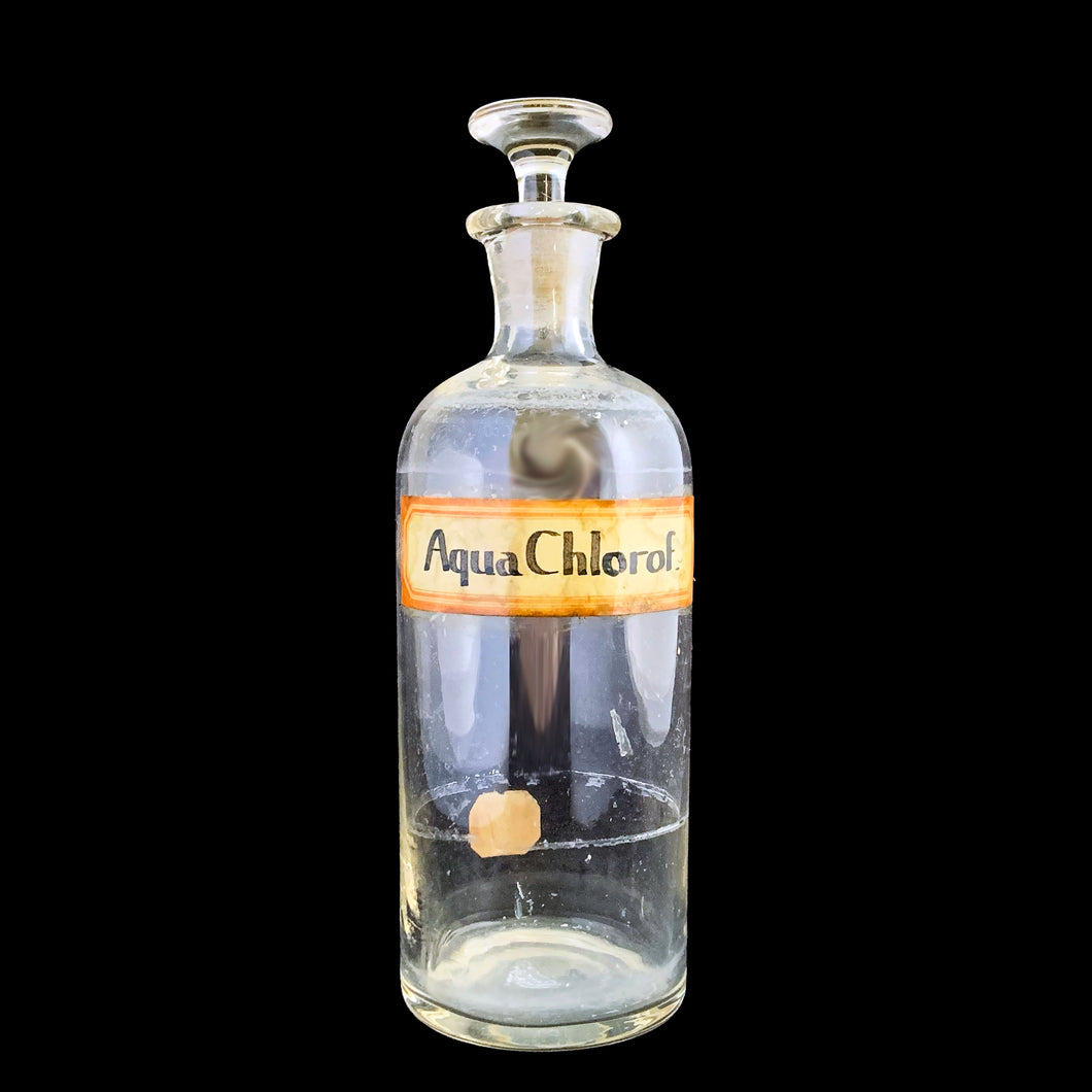 Early 20th century vintage mold blown glass pharmacy chemist apothecary jar with stopper. The hand written label reads Aqua Chlorof in black ink and has a red border which is varnished. These bottles were manufactured to house chemical compounds in pharmacies...a cool piece of history!

In as found condition with age appropriate wear.

Measures 2 3/4 x 8 3/4 inches