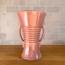 Load image into Gallery viewer, Vintage gloss pink art deco trumpet vase with ribbed design and&nbsp;strap handles. Crafted by Brush McCoy Pottery, 1940s. This rare vase must for any art pottery collector!

In excellent vintage condition, no chips/cracks/repairs. Marked on the bottom, Brush&nbsp; USA 579 8.

Measures 5 5/8 x 8 1/4 inches
