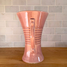 Load image into Gallery viewer, Vintage gloss pink art deco trumpet vase with ribbed design and&nbsp;strap handles. Crafted by Brush McCoy Pottery, 1940s. This rare vase must for any art pottery collector!

In excellent vintage condition, no chips/cracks/repairs. Marked on the bottom, Brush&nbsp; USA 579 8.

Measures 5 5/8 x 8 1/4 inches
