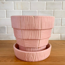 Load image into Gallery viewer, Highly collectible vintage mid-century pink basketweave ceramic planter with attached underplate. Crafted by McCoy Pottery, 1950s. The perfect home for your favourite houseplant or succulent and a must-have for any art pottery collector!

In excellent vintage condition, no chips/cracks/repairs, age-related crazing. Maker&#39;s mark.

Measures 6 1/2 x 5 5/8 inches
