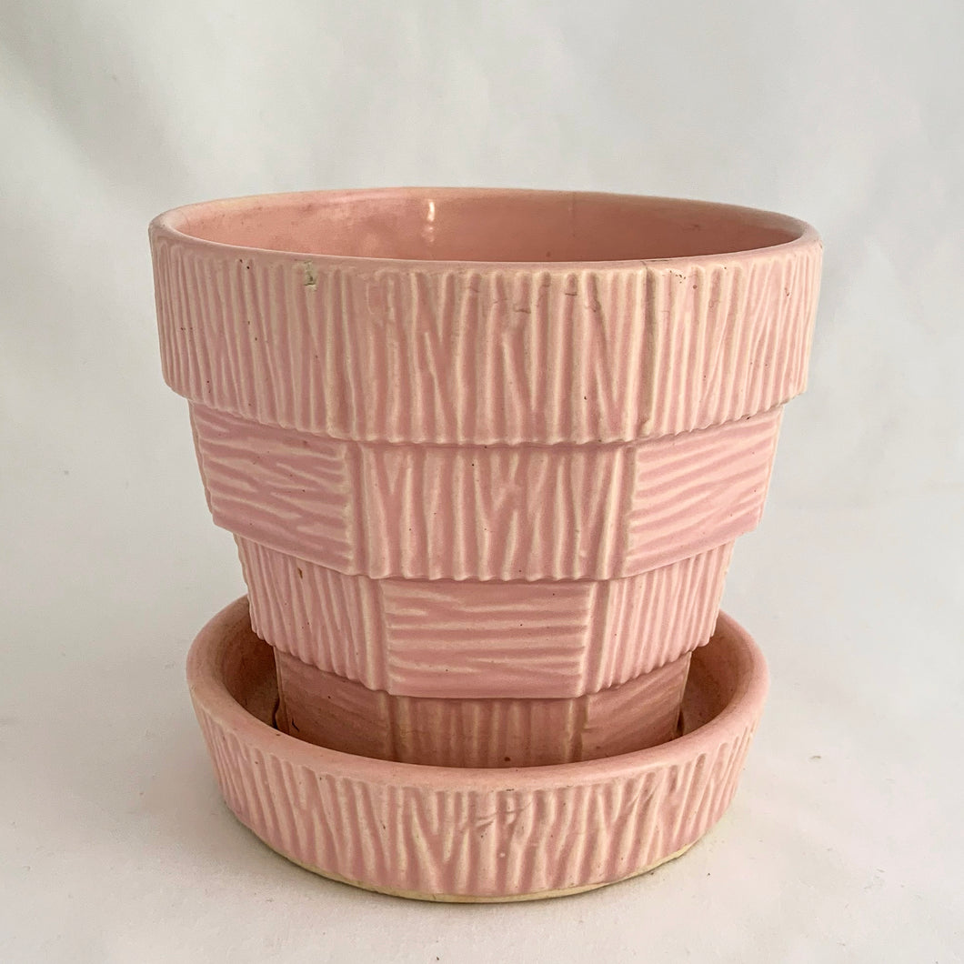 Sweet vintage mid-century pink ceramic planter featuring a basketweave pattern and attached underplate or saucer. Crafted by McCoy Pottery, USA circa 1950s. Highly collectible and absolutely gorgeous, this planter would look great with your favourite houseplant or succulent!  In excellent condition, free from chips/cracks/repairs.  Measures 4 1/4 x 3 7/8 inches