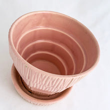 Load image into Gallery viewer, Sweet vintage mid-century pink ceramic planter featuring a basketweave pattern and attached underplate or saucer. Crafted by McCoy Pottery, USA circa 1950s. Highly collectible and absolutely gorgeous, this planter would look great with your favourite houseplant or succulent!  In excellent condition, free from chips/cracks/repairs.  Measures 4 1/4 x 3 7/8 inches
