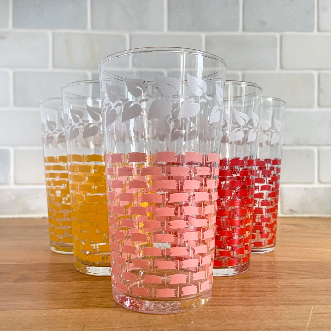 Glassware dreams are made of these beauties! This is a fantastic set of six vintage mid-century beverage glasses decorated in pairs with a pink, yellow or red basketweave pattern topped with a band of white ivy. Produced by Federal Glass, circa 1950s. The perfect addition to any style vintage kitchen and your tablescape will thank you!   In like new condition, free from chips/wear. The paint is vibrant and shiny. Unmarked.  Measures 2 1/2 x 4 1/2 inches  Capacity 12 ounces