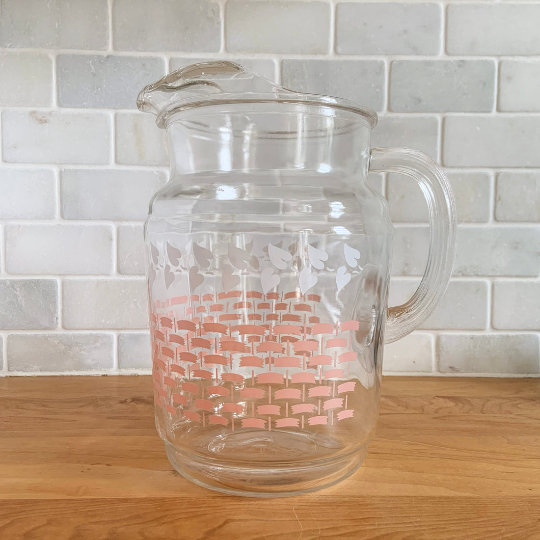 Fantastic vintage mid-century beverage pitcher decorated with a pink basketweave pattern topped with a band of white ivy and ribbed handle. Produced by Federal Glass, circa 1950s. The perfect addition to any style vintage kitchen and your tablescape will thank you! Glassware dreams are made of this beauty!  In like new condition, free from chips/wear. The paint is vibrant and shiny. Unmarked.  Measures 5 x 8 inches  Capacity 90 ounces