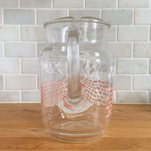 Load image into Gallery viewer, Fantastic vintage mid-century beverage pitcher decorated with a pink basketweave pattern topped with a band of white ivy and ribbed handle. Produced by Federal Glass, circa 1950s. The perfect addition to any style vintage kitchen and your tablescape will thank you! Glassware dreams are made of this beauty!  In like new condition, free from chips/wear. The paint is vibrant and shiny. Unmarked.  Measures 5 x 8 inches  Capacity 90 ounces
