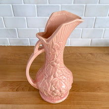 Load image into Gallery viewer, Beautiful vintage Art Deco pink pitcher vase features a unique handle and embossed grapevines. Crafted by McCoy Pottery, 1946. This vase is must for any art pottery collector. A lovely way to enhance your home&#39;s decor or to give as a gift!

In excellent vintage condition, no chips/cracks/repairs. Typical manufacturer&#39;s glaze misses/pops. Maker&#39;s mark on the bottom.

Measures 5 x 9 1/4 inches (incl. handle/spout)
