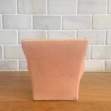 Load image into Gallery viewer, Vintage gloss pink glazed lily bud jardiniere planter No. 39. Crafted by McCoy Pottery, USA, 1948. This collectible planter is the perfect for succulents or decorative display and makes a lovely gift for an art pottery collector.

In excellent vintage condition, no chips, cracks or repairs, manufacturer's glaze pops. Makers mark.

Measures 4 5/8 x 4 1/8 x 4 inches
