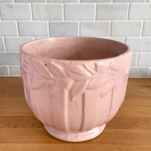 Load image into Gallery viewer, Rare vintage matte pink Sand Butterfly jardiniere planter with embossed vertical bands topped with a border of leaves and butterflies. Crafted by McCoy Pottery, 1930s. This rare planter is must for any McCoy art pottery collector. A wonderful piece to elevate your home and garden decor or to give as a gift!

In as found vintage condition, chips to the rim and crack, no repairs. Normal age-related crazing and manufacturer&#39;s glaze pops. Maker&#39;s mark on the bottom.

Measures 8 x 7 inches
