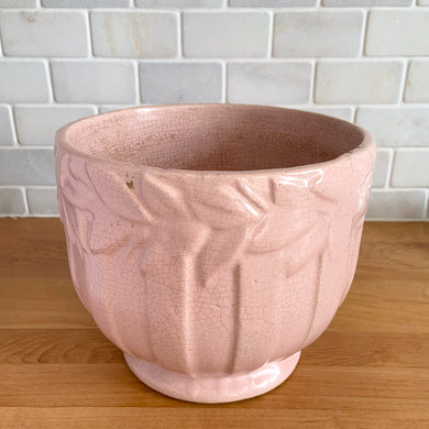 Rare vintage matte pink Sand Butterfly jardiniere planter with embossed vertical bands topped with a border of leaves and butterflies. Crafted by McCoy Pottery, 1930s. This rare planter is must for any McCoy art pottery collector. A wonderful piece to elevate your home and garden decor or to give as a gift!

In as found vintage condition, chips to the rim and crack, no repairs. Normal age-related crazing and manufacturer's glaze pops. Maker's mark on the bottom.

Measures 8 x 7 inches