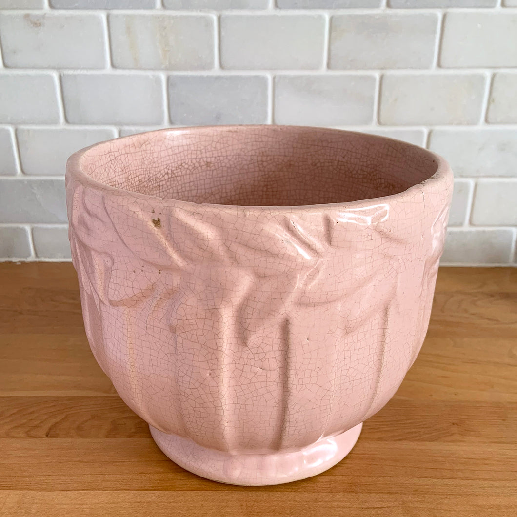 Rare vintage matte pink Sand Butterfly jardiniere planter with embossed vertical bands topped with a border of leaves and butterflies. Crafted by McCoy Pottery, 1930s. This rare planter is must for any McCoy art pottery collector. A wonderful piece to elevate your home and garden decor or to give as a gift!

In as found vintage condition, chips to the rim and crack, no repairs. Normal age-related crazing and manufacturer's glaze pops. Maker's mark on the bottom.

Measures 8 x 7 inches