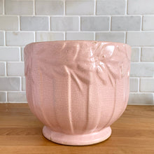 Load image into Gallery viewer, Rare vintage matte pink Sand Butterfly jardiniere planter with embossed vertical bands topped with a border of leaves and butterflies. Crafted by McCoy Pottery, 1930s. This rare planter is must for any McCoy art pottery collector. A wonderful piece to elevate your home and garden decor or to give as a gift!

In as found vintage condition, chips to the rim and crack, no repairs. Normal age-related crazing and manufacturer&#39;s glaze pops. Maker&#39;s mark on the bottom.

Measures 8 x 7 inches
