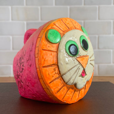Quirky vintage Lion ceramic coin bank hand painted in fluorescent pink, orange and green with embossed mouse on the side. This little sweetheart glows under black light! Designed by Made in Japan, 1970s. So much whimsy in one little bank!

In excellent condition no chips/cracks, wear commensurate with age. No stopper.

Measures 4 1/2 x 4 1/2 x 4 1/2 inches