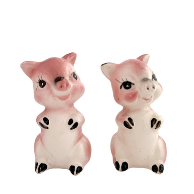 Pair of vintage mid-century era hand painted pink pig ceramic figurines. Made in Japan. An adorable addition to any kitsch decor collection!

In as found vintage condition. One pig has a chip on ear tip.

Measures 2 1/2 inches tall