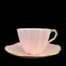 Load image into Gallery viewer, Side profile of vintage EB Foley 1850 scalloped bone china teacup and saucer, pale pink with floral motif and gold gilt
