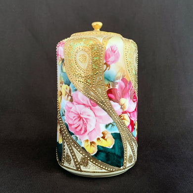 Absolutely exquisite one-of-a-kind hand painted porcelain lidded ginger jar, crafted by artisans in Japan circa late 1800s, early 1900s. It features sweeping panes of pink roses against a yellow and deep teal with alternating peacock feather-like shapes of gold gilt, heavily embellished with moriage, as is the lid. Nippon Porcelain,1891-1921.  