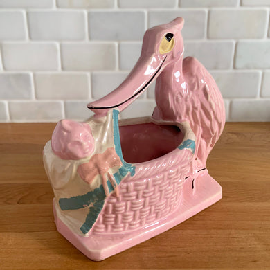 Vintage gloss pink glazed stork nursery ceramic planter with cold painted details. Crafted by McCoy Pottery, 1956. This rare planter is a must-have for any McCoy collector. It makes a wonderful gift for a baby shower and adds a nice touch of whimsy to your baby's nursery decor.

In excellent vintage condition, no chips/cracks/repairs, typical age-related wear to the cold paint. Marked on the bottom.

Measures 7 x 4 1/4 x 7 inches