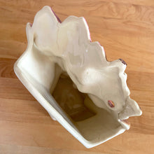 Load image into Gallery viewer, Rare vintage mid-century gloss pink tint magnolia vase with green leaves. Crafted by McCoy Pottery, USA, 1953. This special piece is must for any art pottery collector!

In as found used vintage condition. This vase has several cracks and a repair. Still displays well. Maker&#39;s mark.

Measures 7 x 3 1/2 x 8 1/4 inches

