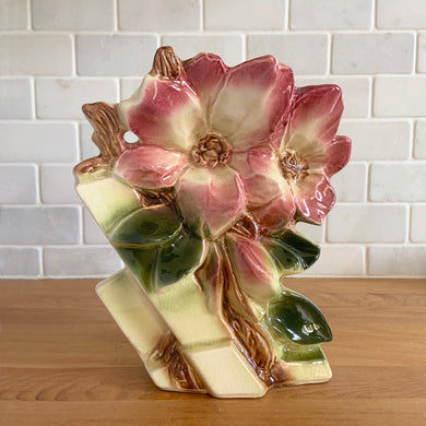 Rare vintage mid-century gloss pink tint magnolia vase with green leaves. Crafted by McCoy Pottery, USA, 1953. This special piece is must for any art pottery collector!

In as found used vintage condition. This vase has several cracks and a repair. Still displays well. Maker's mark.

Measures 7 x 3 1/2 x 8 1/4 inches