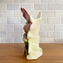 Load image into Gallery viewer, Rare vintage mid-century gloss pink tint magnolia vase with green leaves. Crafted by McCoy Pottery, USA, 1953. This special piece is must for any art pottery collector!

In as found used vintage condition. This vase has several cracks and a repair. Still displays well. Maker&#39;s mark.

Measures 7 x 3 1/2 x 8 1/4 inches
