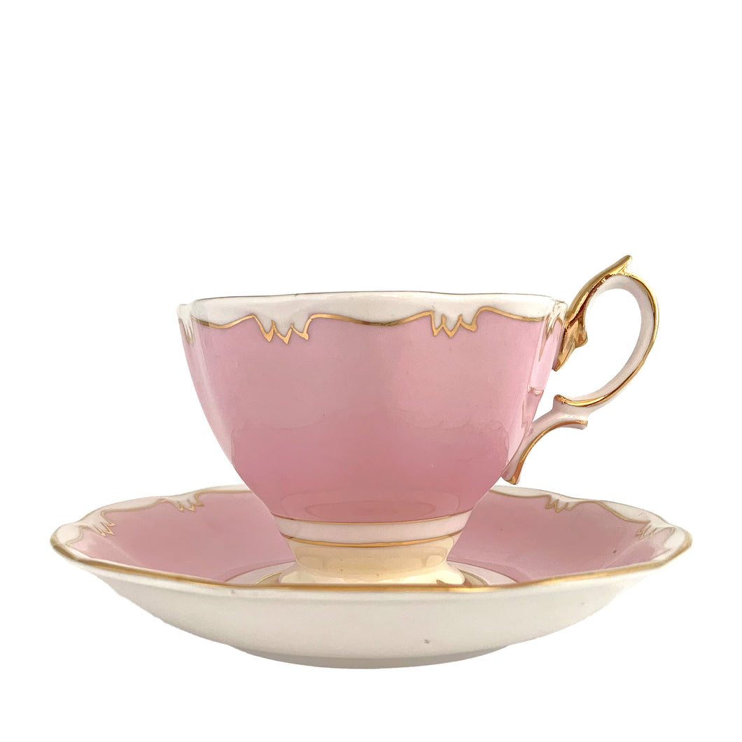 This vintage bone china footed teacup and saucer is so sweet! This teacup and saucer in the Malvern shape are hand painted in pink and pale yellow with a stylized gold git border. Produced by Royal Albert, England, circa 1960s. A lovely addition to your tableware or collection.  In excellent condition, no chips/cracks/repairs. Maker's marks on each piece. Teacup measures 3 1/2 x 2 5/8 inches. Saucer measures 5 1/2 inches