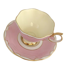 Load image into Gallery viewer, This vintage bone china footed teacup and saucer is so sweet! This teacup and saucer in the Malvern shape are hand painted in pink and pale yellow with a stylized gold git border. Produced by Royal Albert, England, circa 1960s. A lovely addition to your tableware or collection.  In excellent condition, no chips/cracks/repairs. Maker&#39;s marks on each piece. Teacup measures 3 1/2 x 2 5/8 inches. Saucer measures 5 1/2 inches
