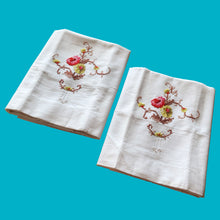 Load image into Gallery viewer, Lovely vintage white cotton pillowcases cross-stitch embroidered florals in shades of pink, yellow green, brown and white. A lovely addition to your bedding collection.

Excellent condition, no stains or tears.

Measures 31 1/2 x 20 inches
