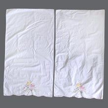 Load image into Gallery viewer, A pair of vintage white cotton pillowcases, featuring elegantly embroidered pink and yellow roses, green leaves with cutwork finished in a sweet pink scalloped edge. A gorgeous addition to your bed linens!

In excellent condition.

Measures 31 1/2 x 19 inches
