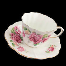 Load image into Gallery viewer, This vintage bone china scalloped shaped teacup and saucer featuring pink roses and gold gilt details. Crafted by Royal Stuart, England, 1948 - 1960. A lovely way to enjoy a cuppa tea.

In excellent condition, no chips, cracks or repairs. Maker&#39;s mark on the bottom.

Teacup measures 3 1/2 x 2 3/4 inches | Saucer measures 5 7/8 inches
