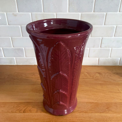 Vintage art deco plum stoneware vase featuring repeating columns of stacked palm leaves. Crafted by Robinson Ransbottom Pottery Co., USA, 1930s. A beautiful piece to add to your art pottery collection!

In as found condition, hairline crack at the rim (see photos), no chips/repairs. Typical manufacturing glaze pops. Unmarked.

Measures 6 1/4 x 10 1/4 inches