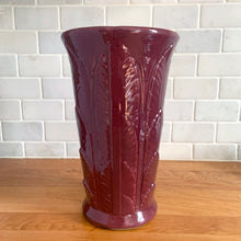Load image into Gallery viewer, Vintage art deco plum stoneware vase featuring repeating columns of stacked palm leaves. Crafted by Robinson Ransbottom Pottery Co., USA, 1930s. A beautiful piece to add to your art pottery collection!

In as found condition, hairline crack at the rim (see photos), no chips/repairs. Typical manufacturing glaze pops. Unmarked.

Measures 6 1/4 x 10 1/4 inches
