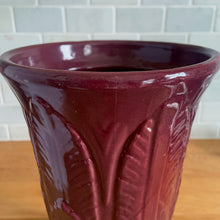 Load image into Gallery viewer, Vintage art deco plum stoneware vase featuring repeating columns of stacked palm leaves. Crafted by Robinson Ransbottom Pottery Co., USA, 1930s. A beautiful piece to add to your art pottery collection!

In as found condition, hairline crack at the rim (see photos), no chips/repairs. Typical manufacturing glaze pops. Unmarked.

Measures 6 1/4 x 10 1/4 inches
