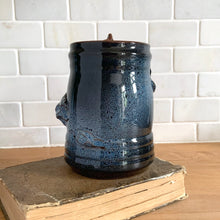 Load image into Gallery viewer, Rare vintage handmade Poseidon and Mermaid redware pottery mug finished in high fired two tone blue glaze on the exterior and a clear glazed interior. This large mug features a figural god of the sea wrapped around the exterior and mermaid in the interior of the mug. Crafted by KD Gandas, Lithuania 1990s. The perfect vessel for your favourite hot beverage!

In excellent condition with original sticker and impressed maker&#39;s mark.

Measures 6 1/4 x 4 1/4 x 6 1/2 inches (incl. handle)

Capacity 16 ounces
