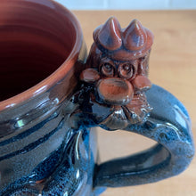 Load image into Gallery viewer, Rare vintage handmade Poseidon and Mermaid redware pottery mug finished in high fired two tone blue glaze on the exterior and a clear glazed interior. This large mug features a figural god of the sea wrapped around the exterior and mermaid in the interior of the mug. Crafted by KD Gandas, Lithuania 1990s. The perfect vessel for your favourite hot beverage!

In excellent condition with original sticker and impressed maker&#39;s mark.

Measures 6 1/4 x 4 1/4 x 6 1/2 inches (incl. handle)

Capacity 16 ounces
