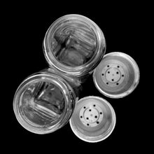 Load image into Gallery viewer, Sail away to flavor-town with this retro vintage set of salt and pepper shakers! These retro-style clear pressed glass shakers feature smooth sides and plasticized chrome screw-on lids. Crafted by Anchor Hocking, circa 1990s. Season your food with a real blast from the past!   The glass is in excellent condition, free from chips/cracks. The lids have very minor wear, see photos. Marked on the bottom.  Measures 1 5/8 x 4 1/8 inches
