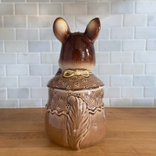 Load image into Gallery viewer, Adorable vintage, mid-century era anthropomorphic ceramic rabbit cookie jar. Crafted by Royal Sealy, Japan, 1950s. A delightful addition to your cookie jar collection and kitchen decor!

In as found vintage condition, with 2 chips to the rim of the lid and a well executed repair to one ear, see photos. No cracks and typical age-related crazing.

Measures 6 x 7 1/4 x 13 1/4 inches
