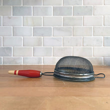 Load image into Gallery viewer, Depression era vintage handheld metal kitchen sieve with a red and cream painted wood handle and hanging loop. Add some charm to your farmhouse or cottage with this useful gadget!

In vintage condition.

Measures 4 1/8 x 9 3/4 x 2 inches
