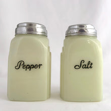 Load image into Gallery viewer, Vintage &quot;Roman Arch&quot; custard uranium glass salt and pepper shaker with the words Salt and Pepper in crisp black script. Produced by McKee Glass, USA, 1930 - 1951. These art deco beauties glow brilliantly under black light and will make a great addition to any vintage kitchen collection!
