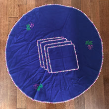 Load image into Gallery viewer, This beautiful vintage set comes with a chic rounded navy blue table cloth, hand-embroidered with a delicate pink crochet edge. The set also includes four matching napkins. An elegant statement piece for any occasion!  All pieces are in excellent condition.  Tablecloth diameter 35 inches  Napkins measure 10 x 10 inches
