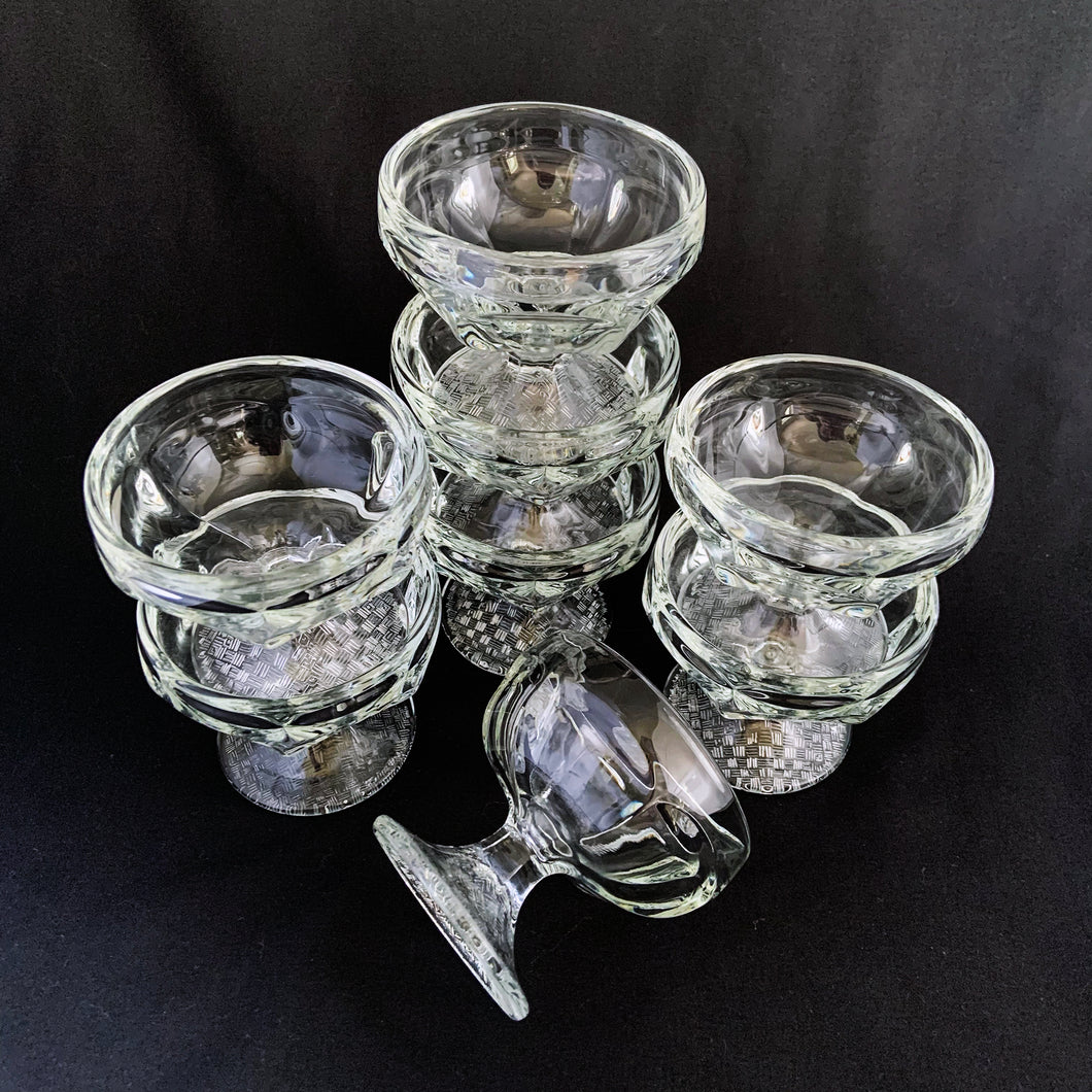 Libbey Glass Company nostalgic clear pressed glass ice cream parlour dishes in stock. They have a quintessential round paneled shape featuring a flared foot impressed basketweave pattern plus the stylized Libbey L on the bottom. Circa 1950s. Perfect for adding a nostalgic touch to desserts - a must-have for all ice cream and dessert lovers! In excellent condition, free from chips/cracks. Measures 3 3/8 x 3 inches. Capacity 4 3/4 ounces